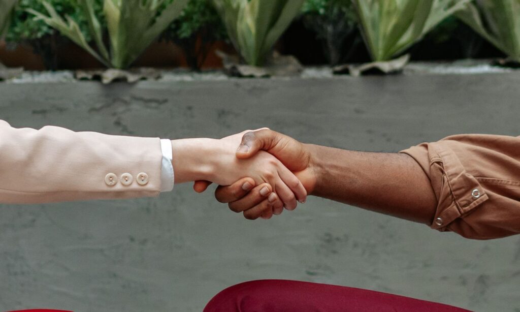 Close-up of diverse hands shaking indoors, symbolizing partnership and agreement.
